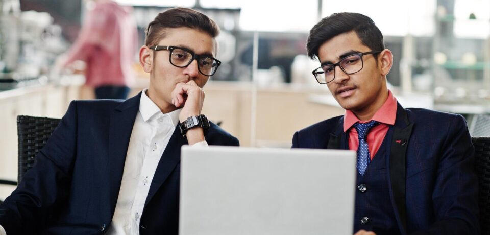 two-indian-business-man-suits-sitting-office-cafe-looking-laptop_627829-1473